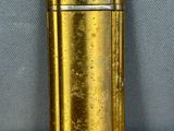 an image of a gold lighter sitting on top of a wooden table