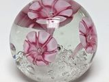 une boule en verre contenant des fleurs roses