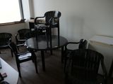 des chaises et une table dans une pièce dotée d'une fenêtre et d'un ordinateur portable