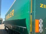 a large green semi truck parked in a parking lot