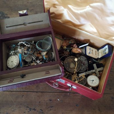 une boîte remplie de bijoux posée sur un plancher en bois