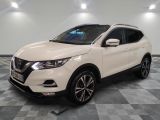 un SUV Nissan blanc garé sur un sol en carrelage à damier