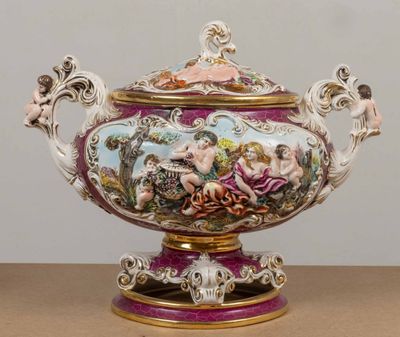 un grand vase avec un tableau posé sur une table