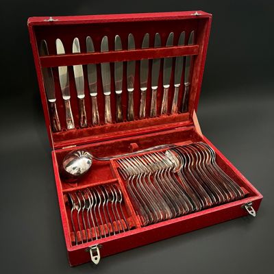 un coffret rouge contenant de l'argenterie, sur fond noir
