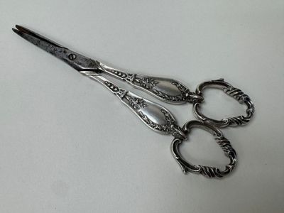 a pair of scissors sitting on a white surface