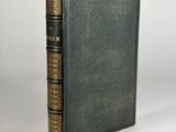 a green book with gold trim and a black cover