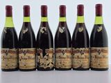 six bouteilles de vin sont alignées sur une table