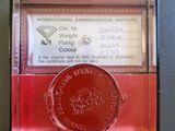 a red coin in a glass case on a table