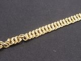 a close up of a gold chain bracelet on a black surface