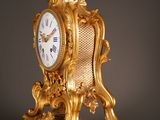 a gold clock that is sitting on top of a table