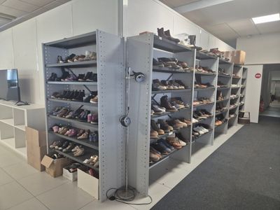 many pairs of shoes on the shelves in the room