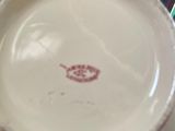 a white plate with a red design on it sitting on a chair