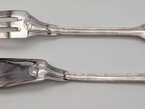 two spoons and a fork sitting on a table