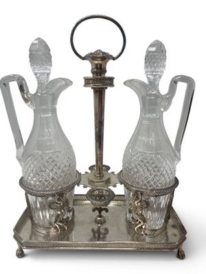 two glass vases sitting on a metal stand