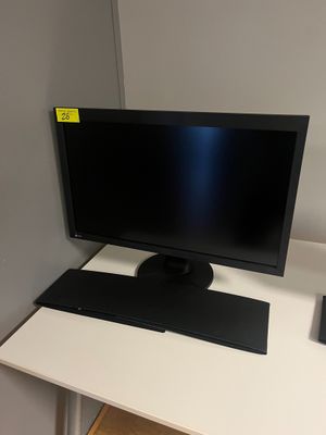 un bureau d'ordinateur sur lequel se trouvent un écran, un clavier et une souris