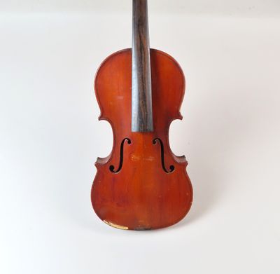 un vieux violon posé sur une surface blanche