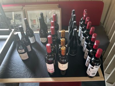 Des bouteilles de vin sont alignées sur une table devant un miroir