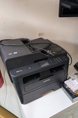 une imprimante posée sur un bureau, à côté d'un téléphone