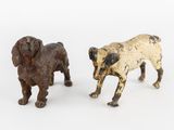 deux figurines de chiens sont placées l'une à côté de l'autre sur une surface blanche