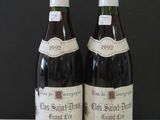 two bottles of wine sitting on top of a table next to each other