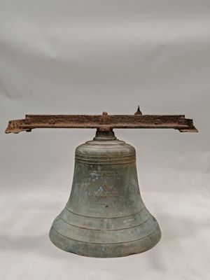 une grande cloche munie d'une poignée en bois sur fond blanc