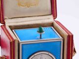 a small clock inside of a red box with a green top
