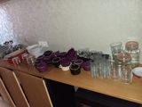 many glasses and cups on a table in a room