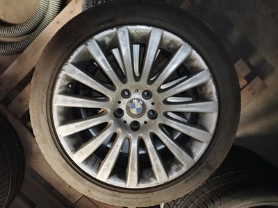 une roue posée par terre à côté de quelques pneus