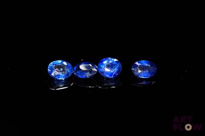 three blue sapphires in a row on a black surface