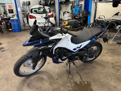a blue and white motorcycle parked in a garage