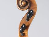 a close up of the back of a violin with a fiddle in the foreground