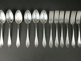 a set of six silverplated spoons and forks on a black background