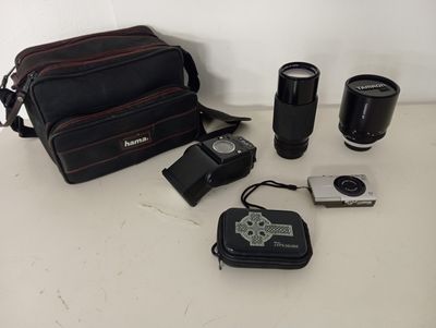 un appareil photo, un objectif, un étui pour appareil photo et un appareil photo posé sur une table