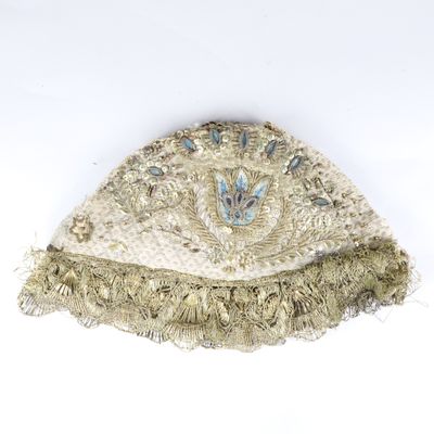 an image of a hat with fringes and beads on a white surface