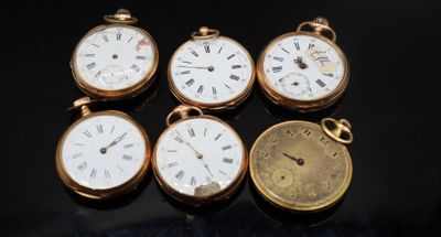 quatre montres de poche différentes posées sur une surface noire