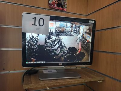 un écran d'ordinateur posé sur un bureau en bois