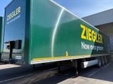 un grand camion vert garé devant un immeuble