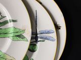 two plates with dragonflies on them and a pair of scissors on the plate