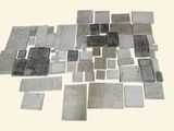 une photo montrant une pile de carreaux argentés posés sur une table