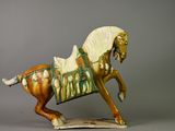 une figurine représentant un cheval avec une selle sur le dos