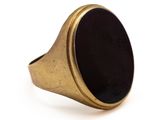 gros plan d'une bague en or avec une pierre noire