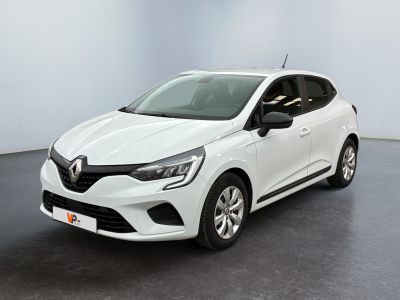 Une voiture blanche est garée dans une pièce au sol noir.