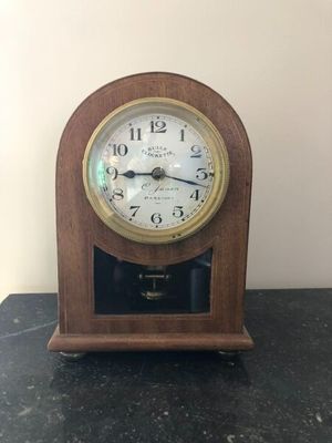 une petite horloge en bois posée sur une table noire