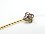 un bâton en or surmonté d'une fleur en diamant