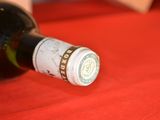 a bottle of wine sitting on a table with a red cloth