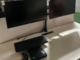 a desk with two monitors and a keyboard on it