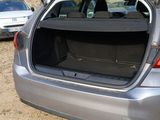 a car that is parked in the dirt with its trunk open