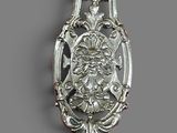an image of a silver spoon with a face on it