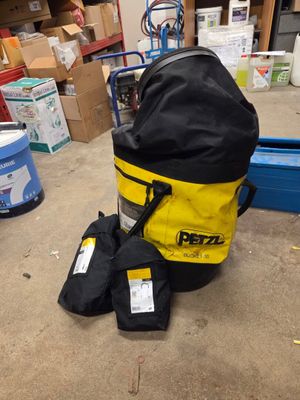 un sac à dos jaune et noir posé par terre à côté d'autres objets