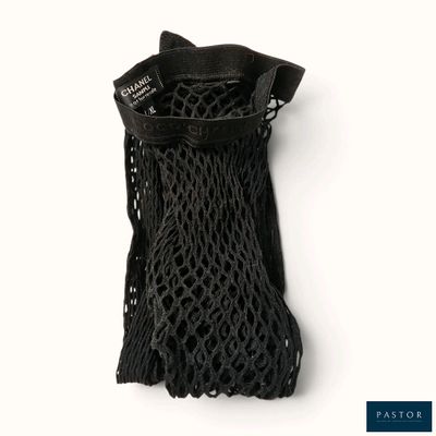 un sac en filet noir muni d'une poignée noire sur un fond blanc